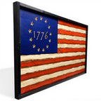 Breacher Rustics carved wooden American flag with a battle-worn look, featuring a blue union with 13 stars and "1776" carved into it, framed in black. betsy ross 1776 wooden american flag wall art carved patriotic colonial flag decor rustic wood flag usa made