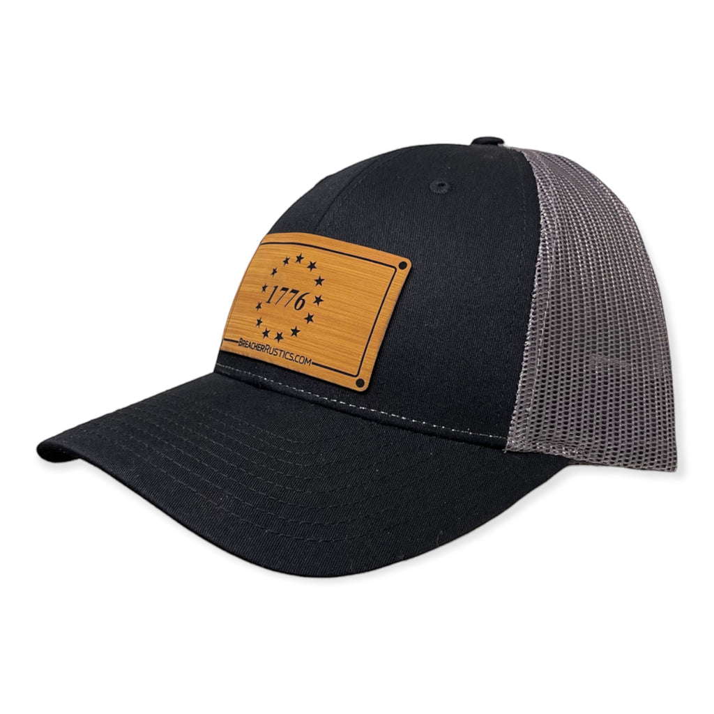 Breacher Rustics black cotton trucker hat with a bamboo leather patch featuring the 1776 Betsy Ross flag design and adjustable snapback.