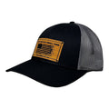 Breacher Rustics black trucker hat with grey mesh back and a bamboo leather patch featuring an American flag and "Try That in a Small Town" text. Jason Aldean