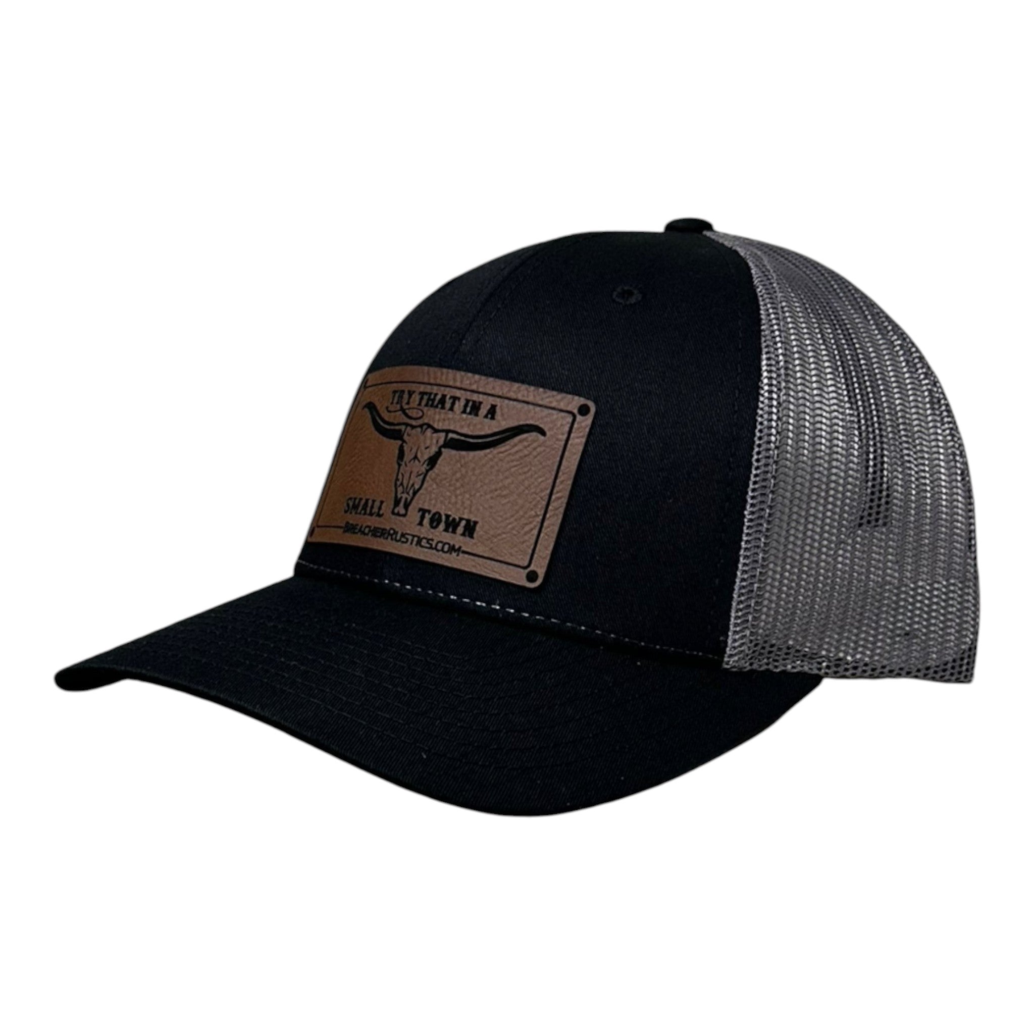 Breacher Rustics black trucker hat with grey mesh back and a brown leather patch featuring a bull skull and "Try That In A Small Town" text. Jason Aldean