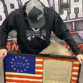 Breacher Rustics black cotton blend pullover hoodie with logo, muff pocket, and ribbed details. Worn by a man with a baseball cap. breacher rustics hoodie patriotic apparel military first responder hoodie soft athletic fit usa made style