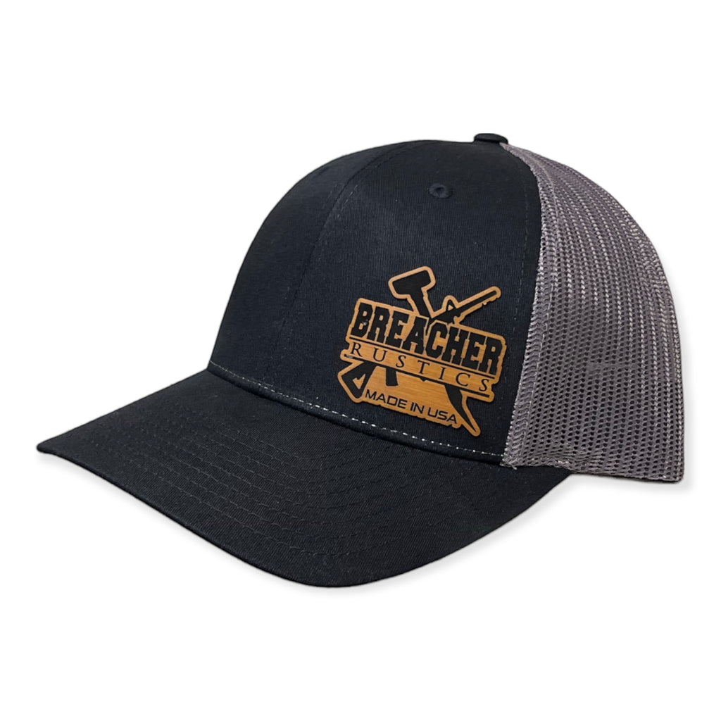 Breacher Rustics black cotton/nylon trucker hat with grey mesh back and leather patch. Structured, six-panel, low-profile with snapback.