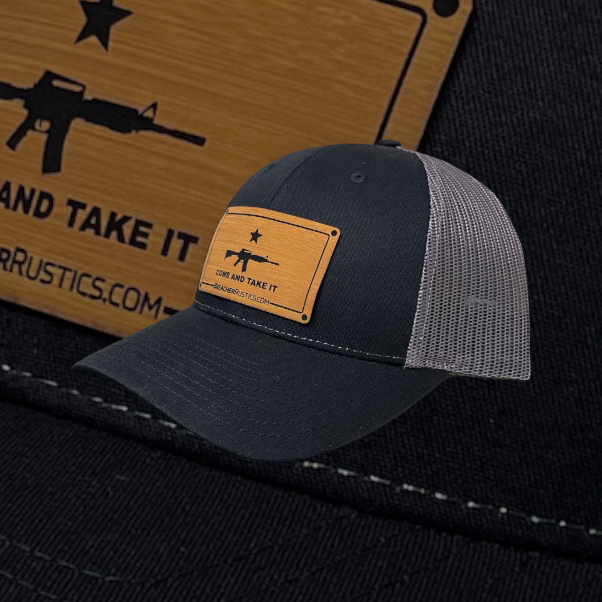 Breacher Rustics dark navy cotton/nylon trucker hat with grey mesh back and a bamboo leather patch featuring the "Come and Take It" slogan and rifle graphic.