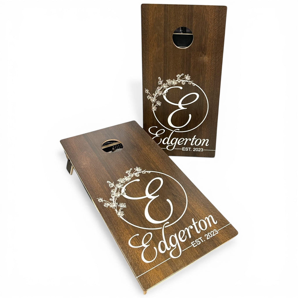 Breacher Rustics custom dark wood cornhole set with white established date and floral initial design.