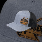 Breacher Rustics grey trucker hat with black mesh back and leather patch logo. Structured, six-panel, low-profile with snapback closure.