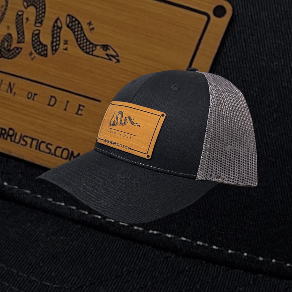 Breacher Rustics black cotton-nylon trucker hat with bamboo leather patch featuring the Join, or Die snake emblem and adjustable snapback.