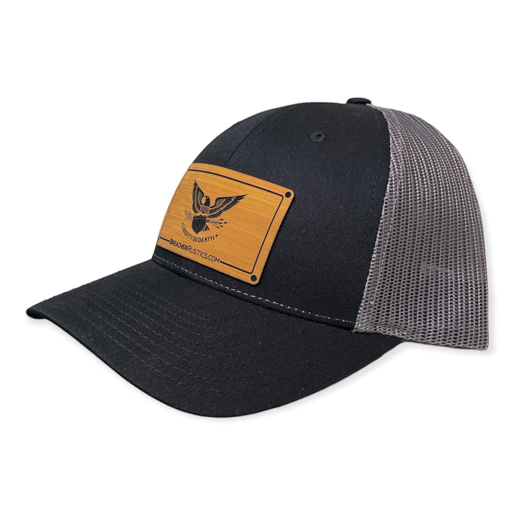 Breacher Rustics black cotton/nylon trucker hat with grey mesh back and a bamboo leather patch featuring an eagle and "Liberty or Death" text.