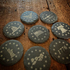 Breacher Rustics Patriot Pack set of 8 round live edge slate coasters featuring patriotic US symbols like the flag, Statue of Liberty, and 1776.