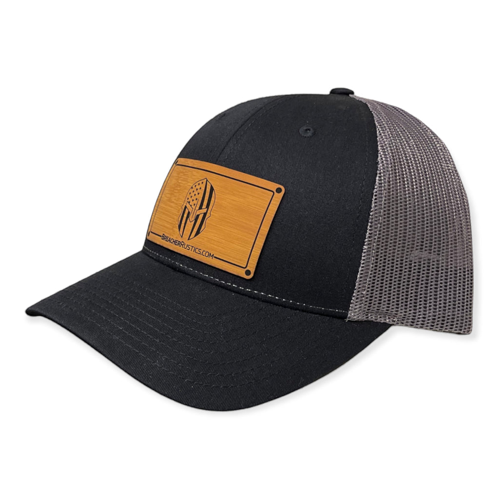 Breacher Rustics black trucker hat with grey mesh back and bamboo leather patch featuring a Spartan helmet with American flag design.