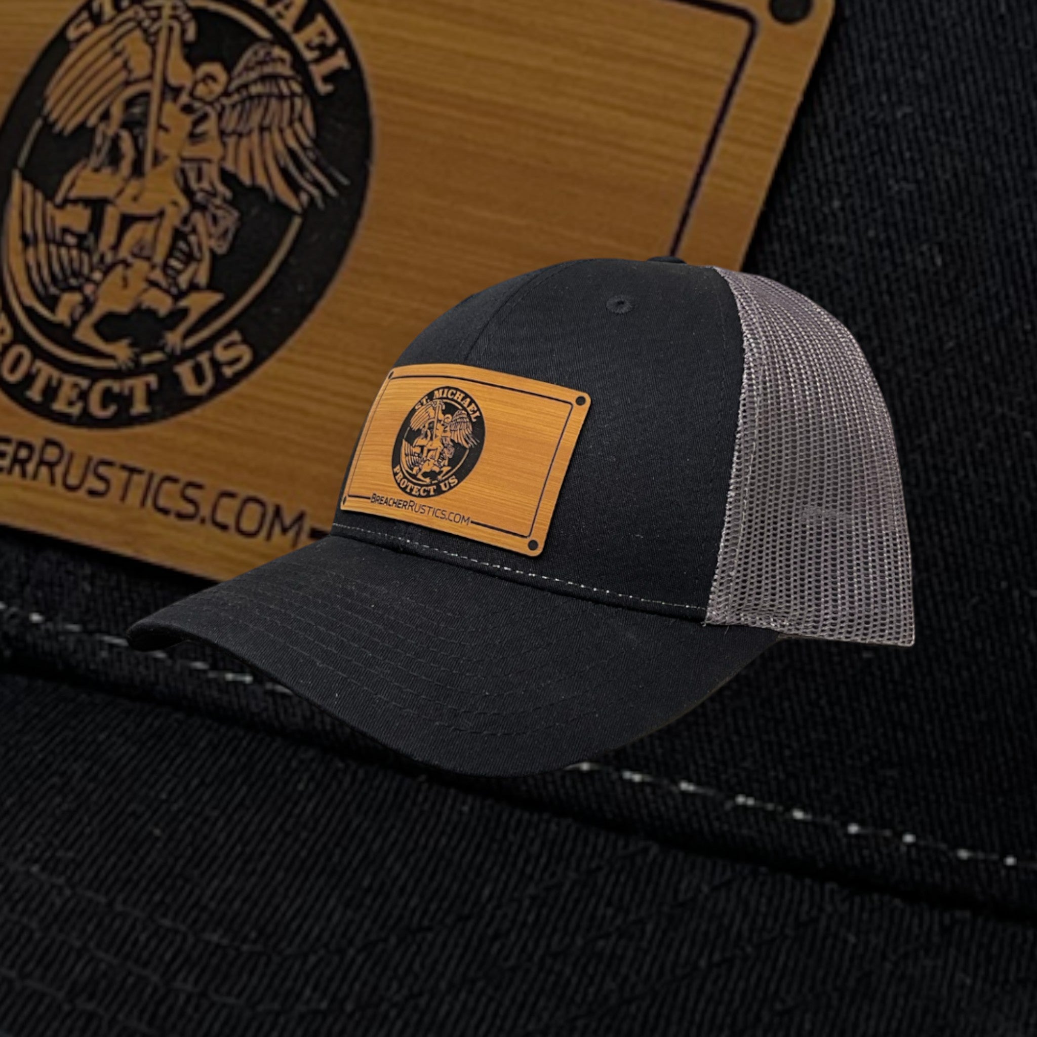 Breacher Rustics black trucker hat with St. Michael patch and grey mesh back. Cotton/nylon blend.