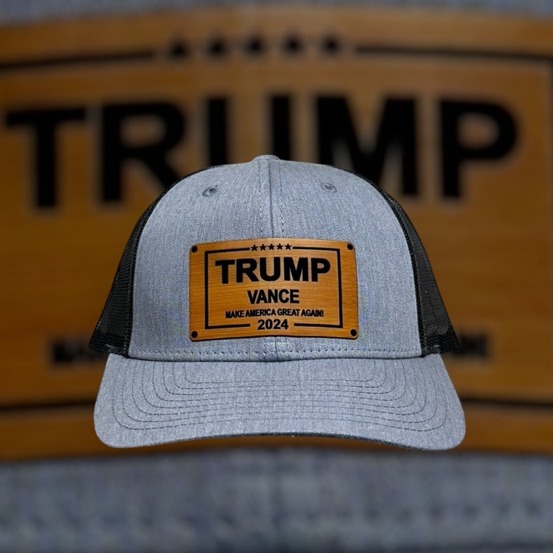 Breacher Rustics grey cotton blend trucker hat with black mesh back and bamboo leather patch featuring Trump Vance 2024 Make America Great Again.