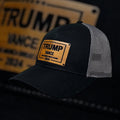 Breacher Rustics Trump Vance 2024 black trucker hat with bamboo leather patch and grey mesh back. Adjustable snapback.