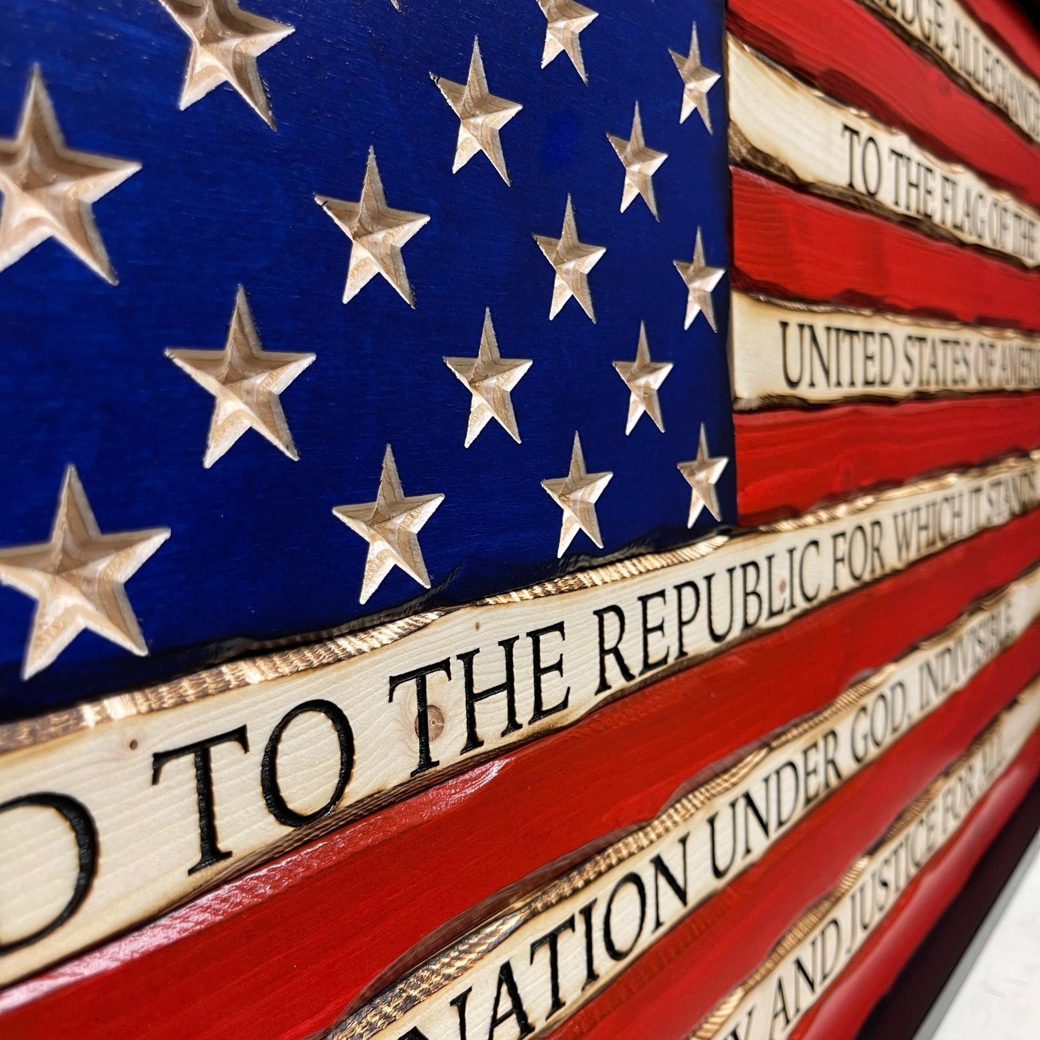 Breacher Rustics battle-worn carved wood American flag with Pledge of Allegiance text and carved stars. Red and blue finish. pledge of allegiance wooden flag wall art carved patriotic american decor engraved wood flag usa made