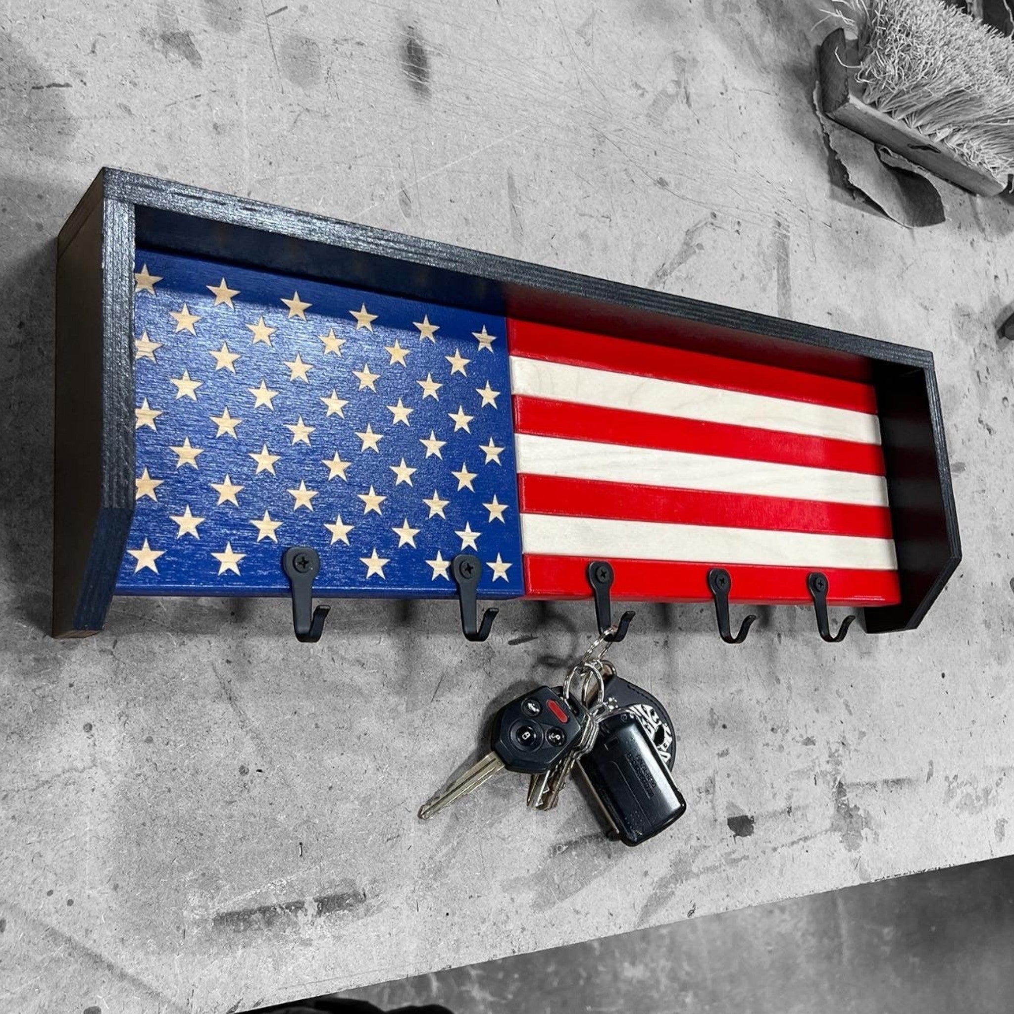 Breacher Rustics USA flag key rack with black hooks, made of wood with blue field and stars, red and white stripes. usa flag key rack wooden wall organizer patriotic entryway key holder rustic american flag decor